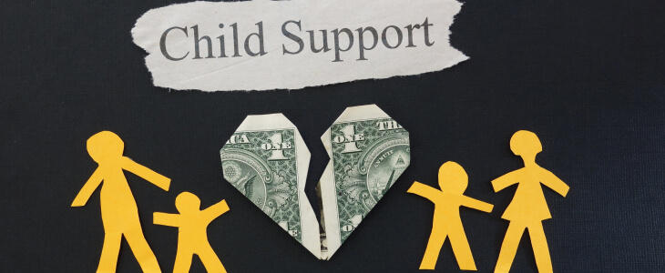Paper cutout reading Child Support with a folded up dollar bill and cutouts of people